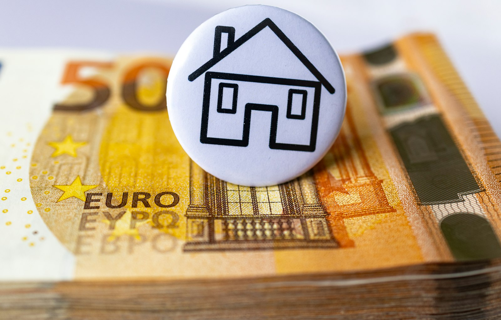 Stapel 50-euro biljetten met huis-icoon symboliseert het vermogen van Stefan Jurriens (1,5 tot 2 miljoen euro)
